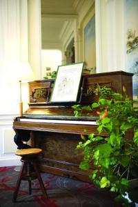a piano in a room with a picture on it at Résidence de Tourisme Vacances Bleues Villa Regina in Arcachon
