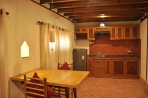 a kitchen with a wooden table and a refrigerator at Boutique Heritage Home in Pātan