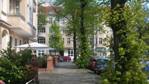 una calle con coches estacionados en el lateral de un edificio en Pension Tempelhof, en Berlín