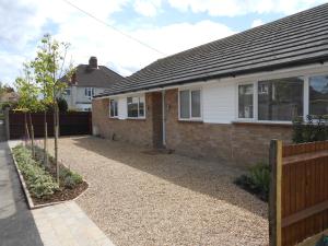 a house with a gravel driveway in front of it at Luxury 4 Bed 3 Bathroom Bungalow , South West of London, The Dapples in Epsom