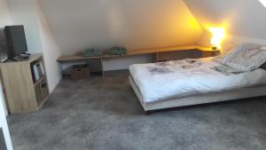 a bedroom with a bed and a flat screen tv at La mouette in Ploeren