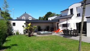 einen Hinterhof eines Hauses mit einer Terrasse mit einem Tisch und Stühlen in der Unterkunft La mouette in Ploeren