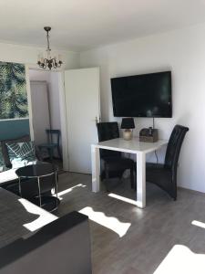 a living room with a white table with chairs and a television at Hornbacher Vogelhaus in Hornbach