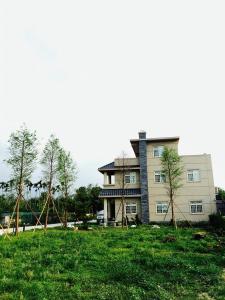 a house with trees in front of it at Dilly Dally B&B in Gukeng