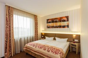 une chambre d'hôtel avec un lit et une fenêtre dans l'établissement Hotel Alte Post, à Lehrte