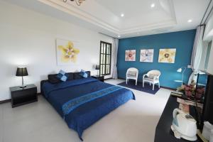 um quarto com uma cama azul e paredes azuis em Baan Ing Khao em Pak Chong