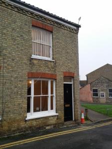 a brick building with a window and a door at St Giles, Thetford, 2BR House in Thetford