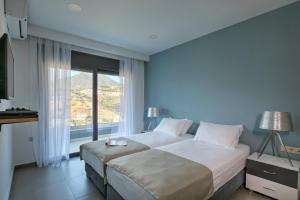 a bedroom with a large bed and a large window at Villa Elli in Balíon