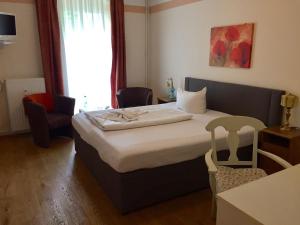 une chambre d'hôtel avec un lit et une chaise dans l'établissement Pension Tempelhof, à Berlin
