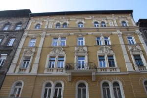 ブダペストにあるAlessia Apartment City Centerの窓とバルコニー付きの大きな黄色の建物
