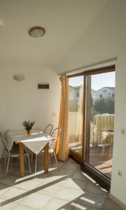 Zimmer mit einem Tisch und Stühlen sowie einem Balkon in der Unterkunft Apartments Villa Višnja in Pašman