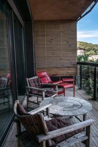 patio z krzesłami i stołem na tarasie w obiekcie Immeuble La Mer w mieście Porto-Vecchio