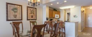 cocina con mesa de cristal y algunas sillas en Penthouse Blue Heron Condo en Orlando