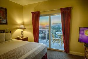 a bedroom with a bed and a balcony with a television at Penthouse Blue Heron Condo in Orlando