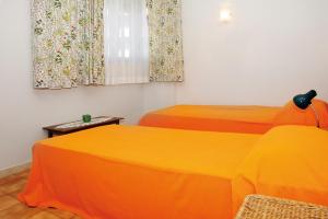 リニャーノ・サッビアドーロにあるAppartamento Aristonのオレンジのシーツが備わるベッド2台(1室あたり)
