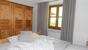 a bedroom with a bed with white sheets and a window at Haus am Osterbrünnl in Ruhmannsfelden