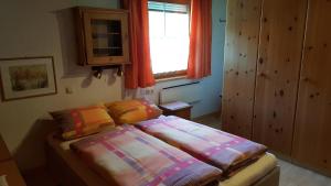 een slaapkamer met een bed met kleurrijke lakens en een raam bij Ferienwohnungen Felder in Schruns