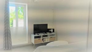 a living room with a tv and a window at LOCATIONS RIVES DE SEUGNE - Claveau in Jonzac