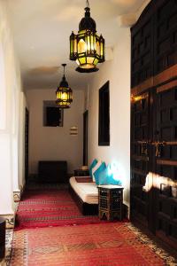 1 dormitorio con cama, lámpara de araña y puerta en Riad Al Mamoune, en Marrakech