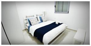 a bedroom with a bed with blue and white pillows at Red Mountains apartments in Eilat