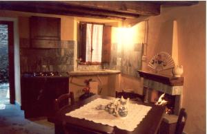Borgo Isola Santa في Isola Santa: مطبخ مع طاولة ومدفأة