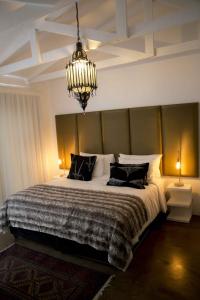 a bedroom with a large bed and a chandelier at The Rez Guesthouse in Walvis Bay