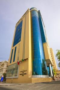 un edificio alto con ventanas azules en una calle en Kingsgate Hotel Doha by Millennium Hotels, en Doha