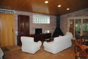 a living room with white chairs and a fireplace at La Vinya de Mas Pujol in Suria