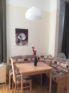 einen Esstisch und Stühle mit Vase drauf in der Unterkunft FEWO Mövennest in Borkum