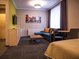 a hotel room with a couch and a table at Aparthotel CENTRUM Gliwicka 18 in Bytom +20 photos