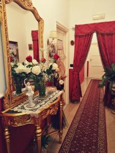 a room with a mirror and a table with flowers at B&B Divina Roma in Rome
