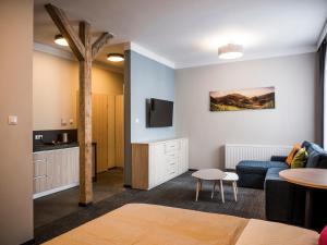 a living room with a blue couch and a table at Aparthotel CENTRUM Gliwicka 18 in Bytom