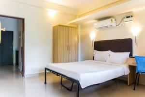 Un dormitorio con una cama blanca y una silla azul. en Lazy Frog Guest House, en Cavelossim 65 fotos más