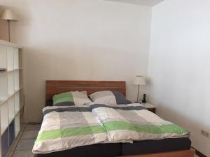 ボルクムにあるFEWO Austerのベッドルーム1室(緑と白の毛布を使用したベッド1台付)