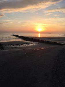 ボルクムにあるFEWO Austerの海に沈む夕日を眺めながらのビーチでの夕日