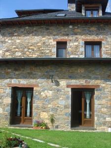 a stone building with three windows on the side of it at Hotel Rural El Caseron de Linarejos in Linarejos