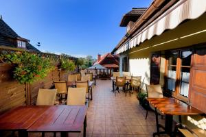 un patio al aire libre con mesas y sillas de madera en Pensjonat Pod Wietrzną Górą, en Kazimierz Dolny