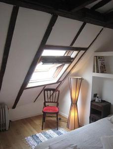 um quarto com uma cama, uma cadeira e uma janela em SOHO CENTER/MARAIS/POMPIDOU/LOUVRE em Paris