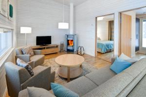 Una sala de estar con un sofá y una chimenea. en Holiday Club Kuusamon Tropiikki Superior Apartments, en Kuusamo