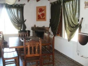 una sala da pranzo con tavolo e sedie in legno di Cabañas del Peñasco ad Alpa Corral