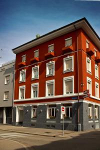 ein rotes Gebäude an der Ecke einer Straße in der Unterkunft Hotel Locanda in Basel