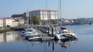 a bunch of boats are docked in the water at Areia Beach Guest House in Vila do Conde