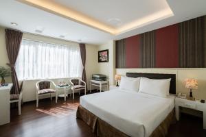 A bed or beds in a room at Asian Ruby Center Point Hotel & Spa