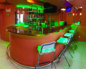 a bar with green bar stools in a restaurant at Hotel Locanda in Basel