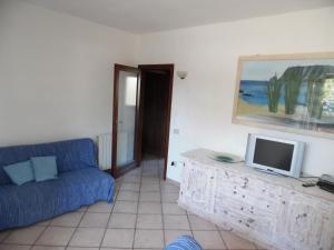 a living room with a blue couch and a tv at Villa Maestrale in Olbia