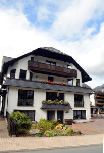 a large white building with flowers in the windows at Hotel Leise Garni in Willingen