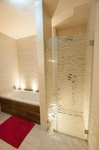 a bathroom with a shower and a bath tub at Prestige apartment in Komárno