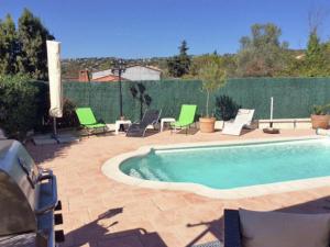 モントルーにあるTasteful Villa in Montauroux with Private Poolの緑の椅子とフェンス付きのスイミングプール