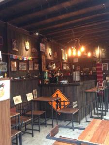 a room with a table and chairs and a bar at The Shadow House & Bar in Ko Phayam