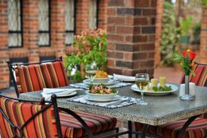 una mesa con platos de comida y copas de vino en Cresta Churchill Hotel, en Bulawayo